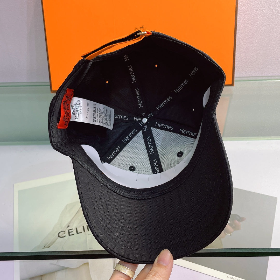 Black Hermes cap with visible branding on a blurred background
