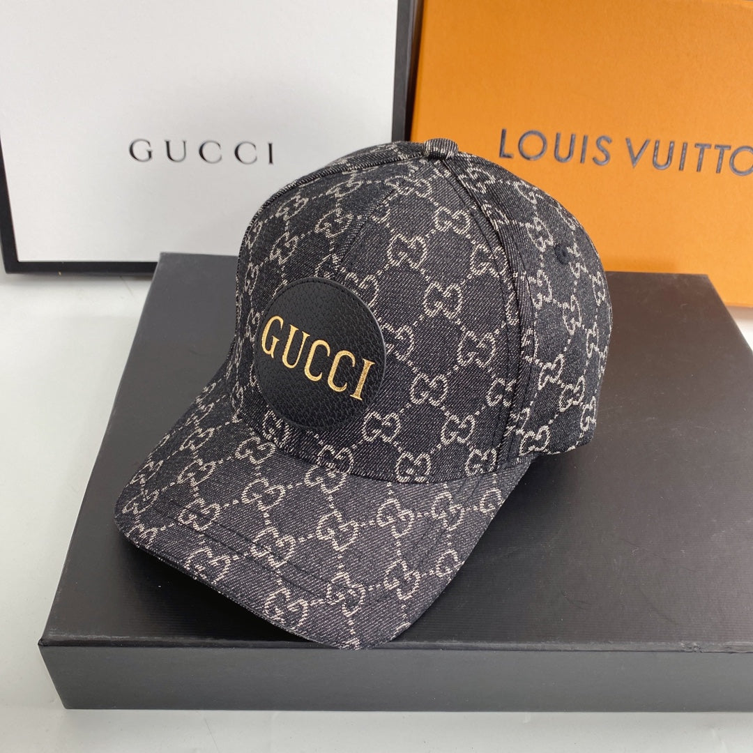 Gucci cap with logo on a black box, with Gucci and Louis Vuitton boxes in the background.