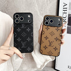 Two phone cases with a monogram pattern held by hands against a neutral background.
