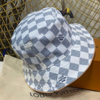 Checkered bucket hat with 'Louis Vuitton' branding on a branded surface.