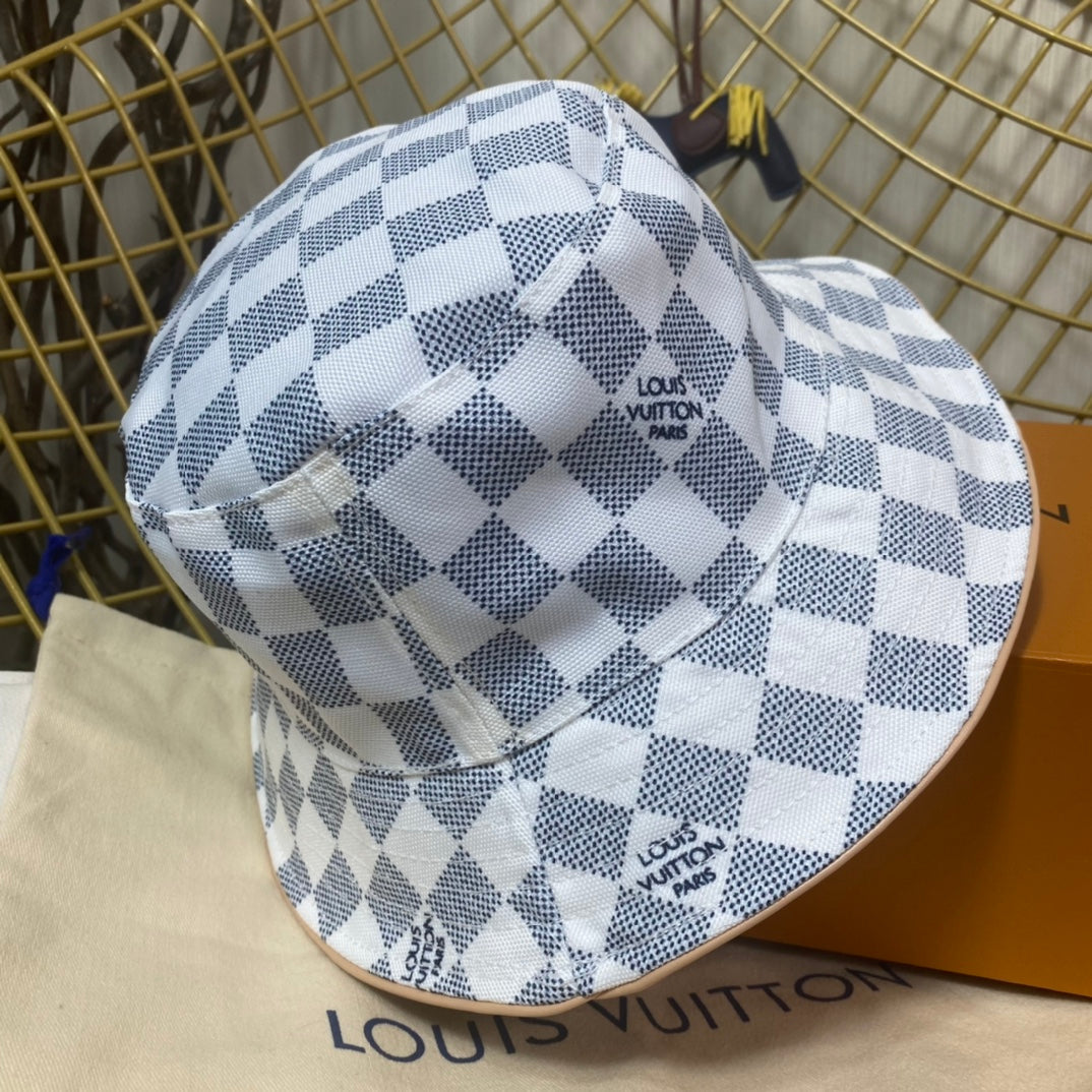Checkered bucket hat with 'Louis Vuitton' branding on a branded surface.