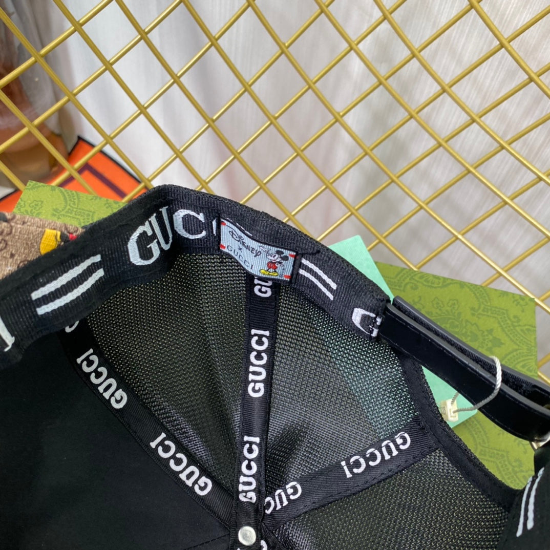 Black Gucci cap with brand logo on mesh back against a gold grid background