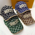 Four Gucci-patterned hats in different colors on a white surface with a Louis Vuitton box in the background.