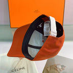 Orange cap with black interior against an orange Hermes box