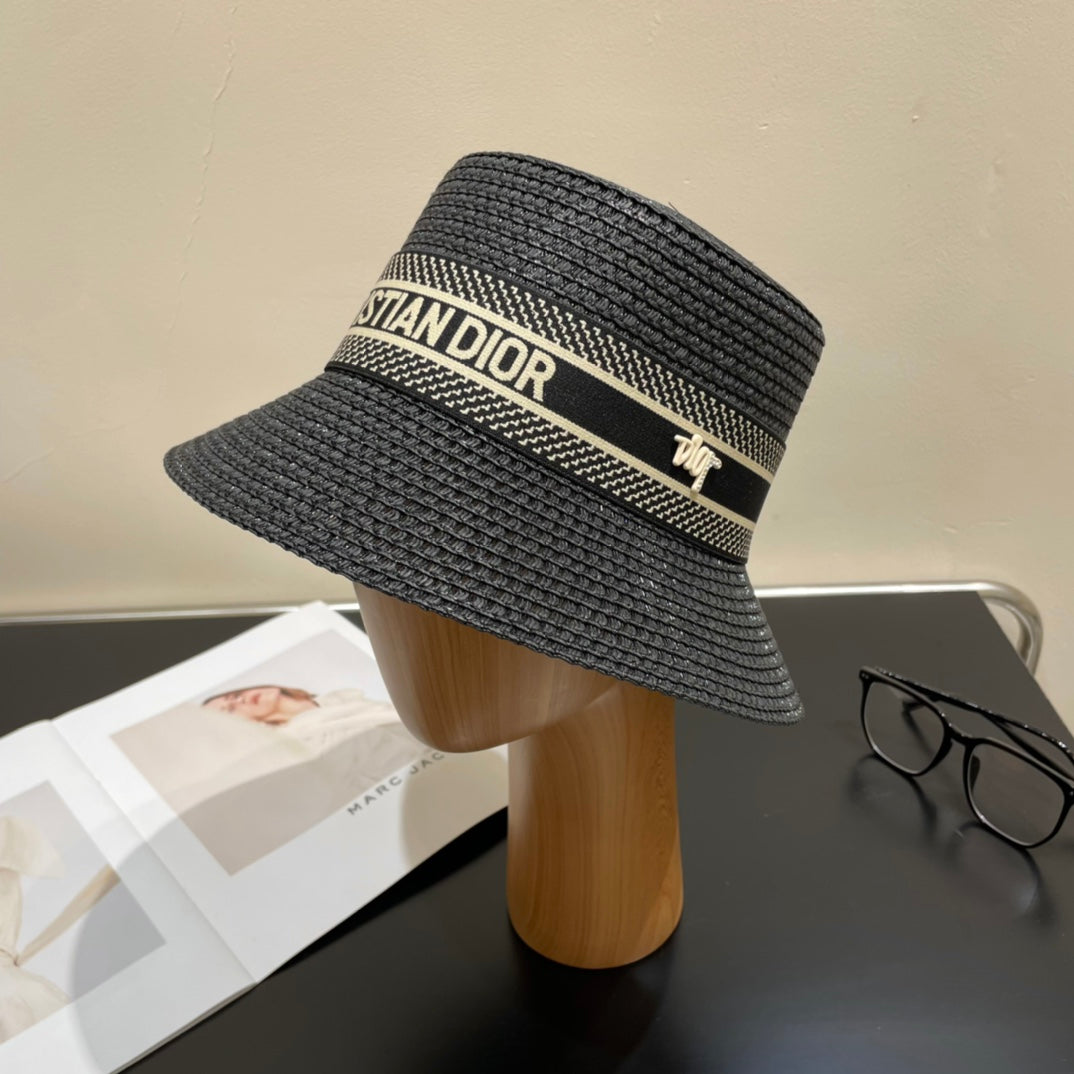 Black straw hat with 'Christian Dior' logo on a mannequin head against a neutral background.