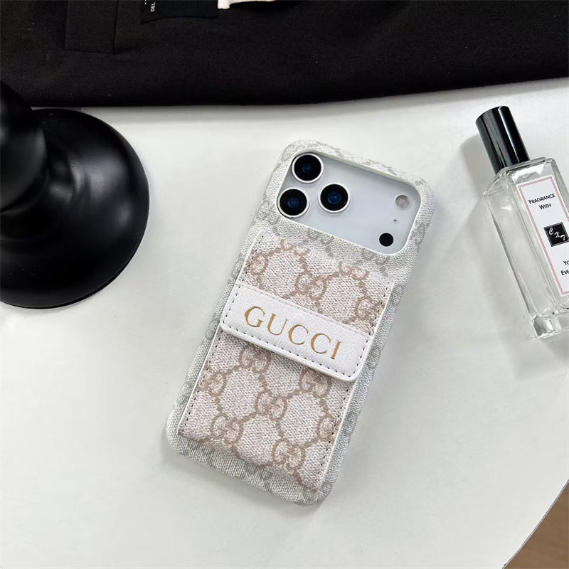 Gucci phone case on a white surface with a bottle of perfume.