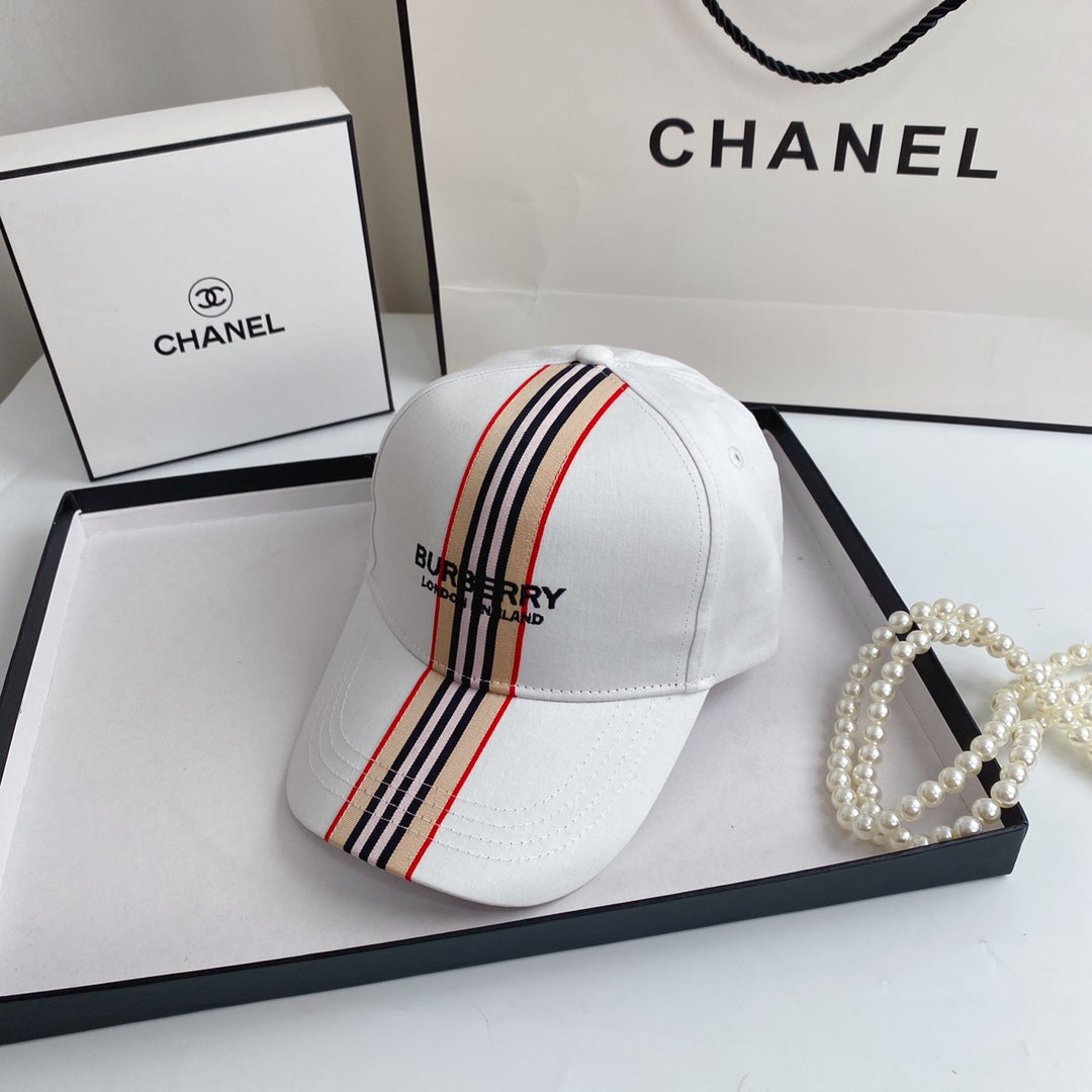 White Burberry cap with striped detail on a Chanel branded surface