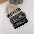 Beige, gray, and black beanie with 'Christian Dior' branding on a white background