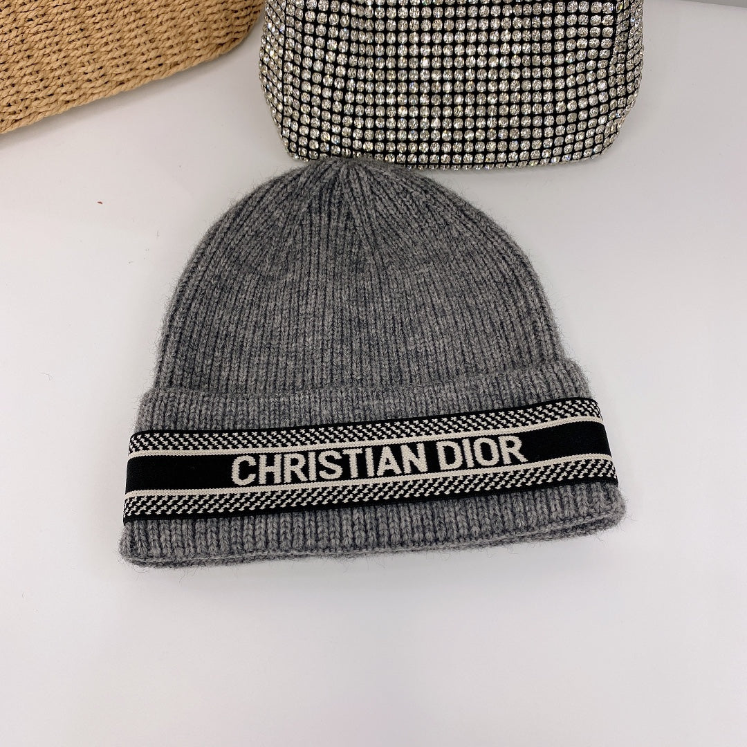 Gray beanie with a black band featuring 'Christian Dior' on a white background