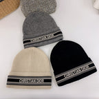 Three beanie hats with Christian Dior branding on a white background