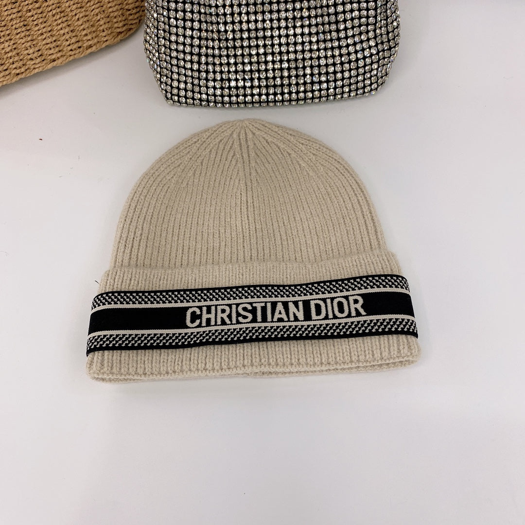 Beige beanie with a black Christian Dior band on a white background