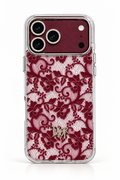 A Dior iPhone case featuring a burgundy lace pattern over a clear mesh backing, with a gold-tone Dior logo at the bottom and a matching burgundy camera ring.