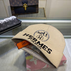 Beige Hermes cap with logo on a reflective surface