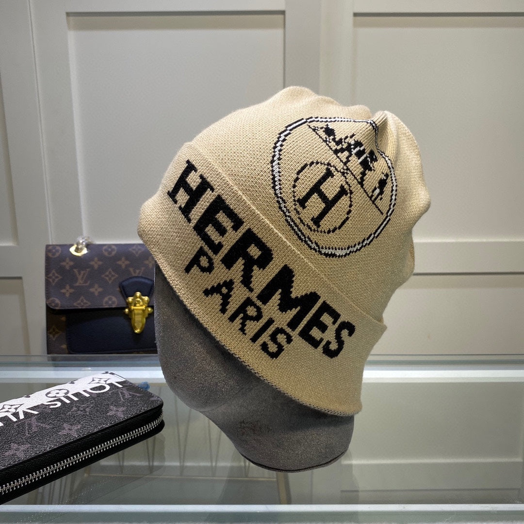 Beige 'Hermes Paris' beanie on a mannequin head with a blurred background