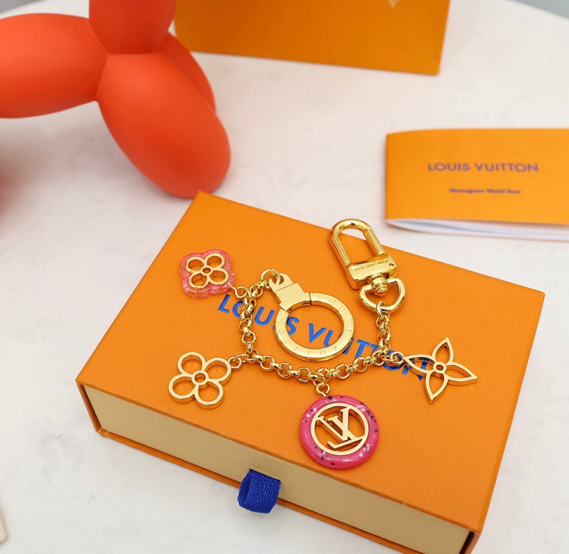 Close-up of Louis Vuitton flower charm keychain with enamel floral pendants