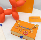 Louis Vuitton flower charm keychain detail with gold-tone clasp and floral charms