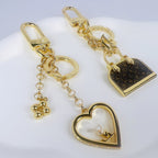 Gold keychain with heart and lock designs on a white background