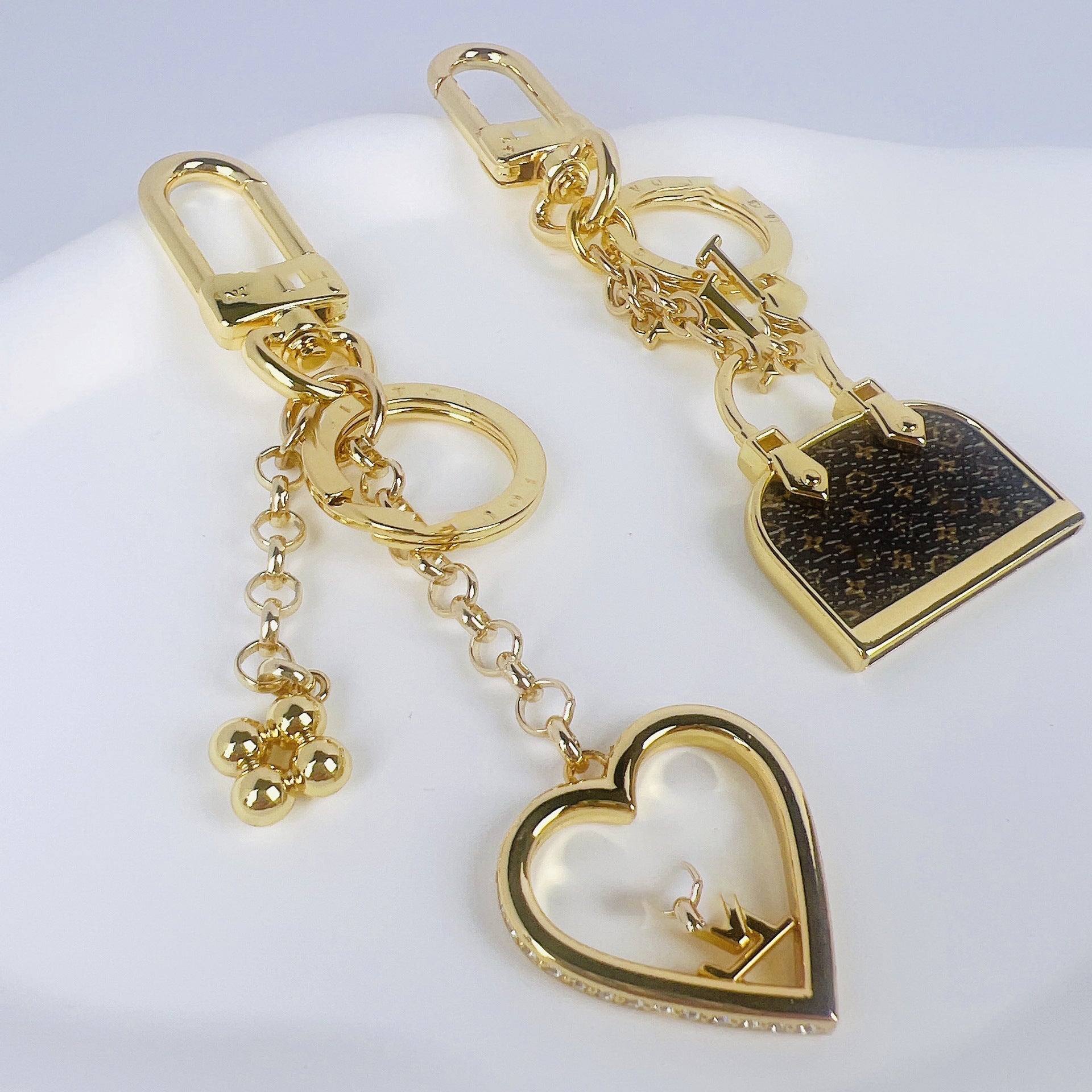 Gold keychain with heart and lock designs on a white background