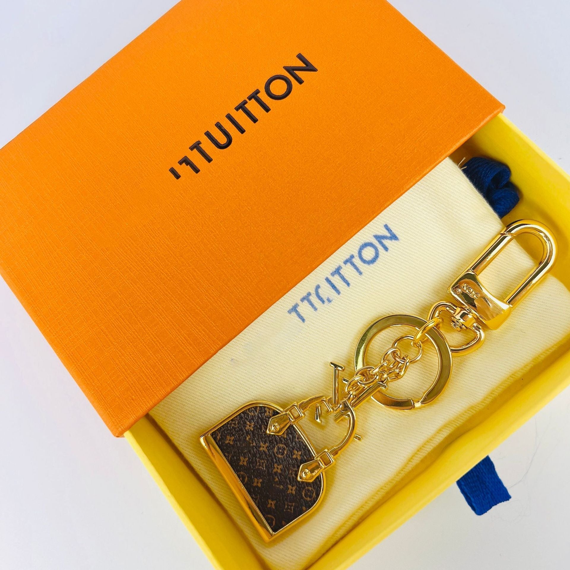 Louis Vuitton monogram mini bag charm keychain displayed in orange box