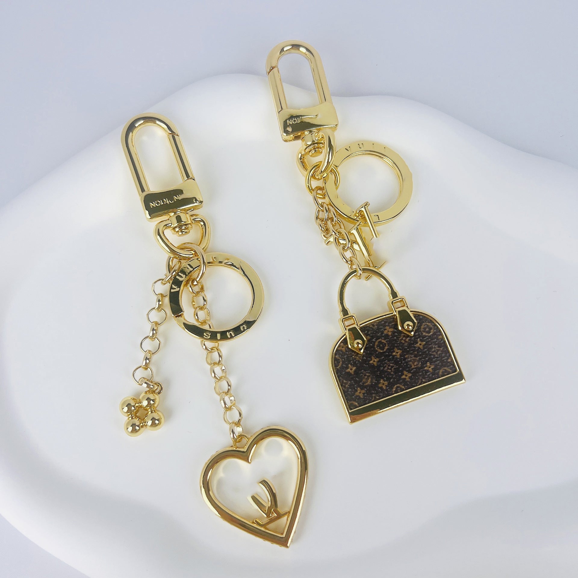 Louis Vuitton monogram mini bag and heart charm keychains on display