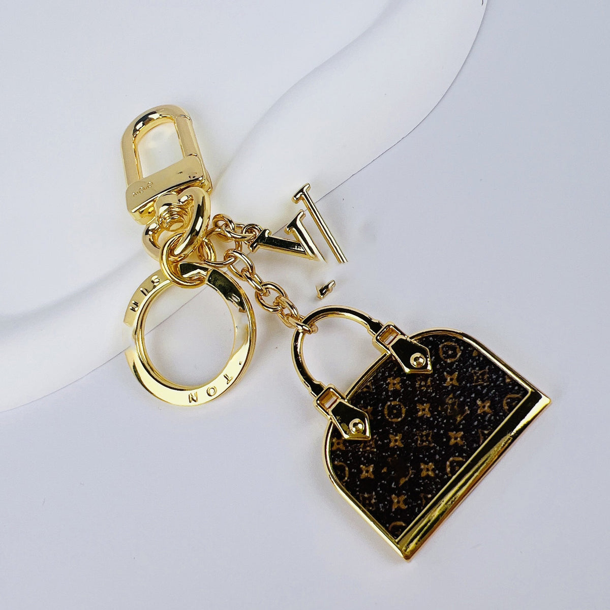Angled view of Louis Vuitton monogram mini bag charm keychain