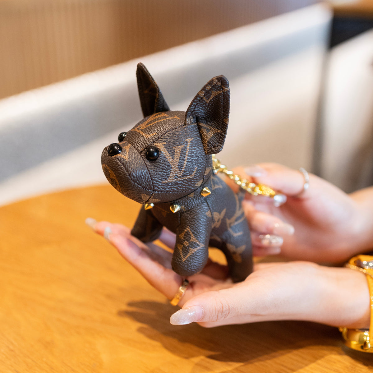 Handheld Louis Vuitton monogram puppy keychain with gold-tone chain and studded collar