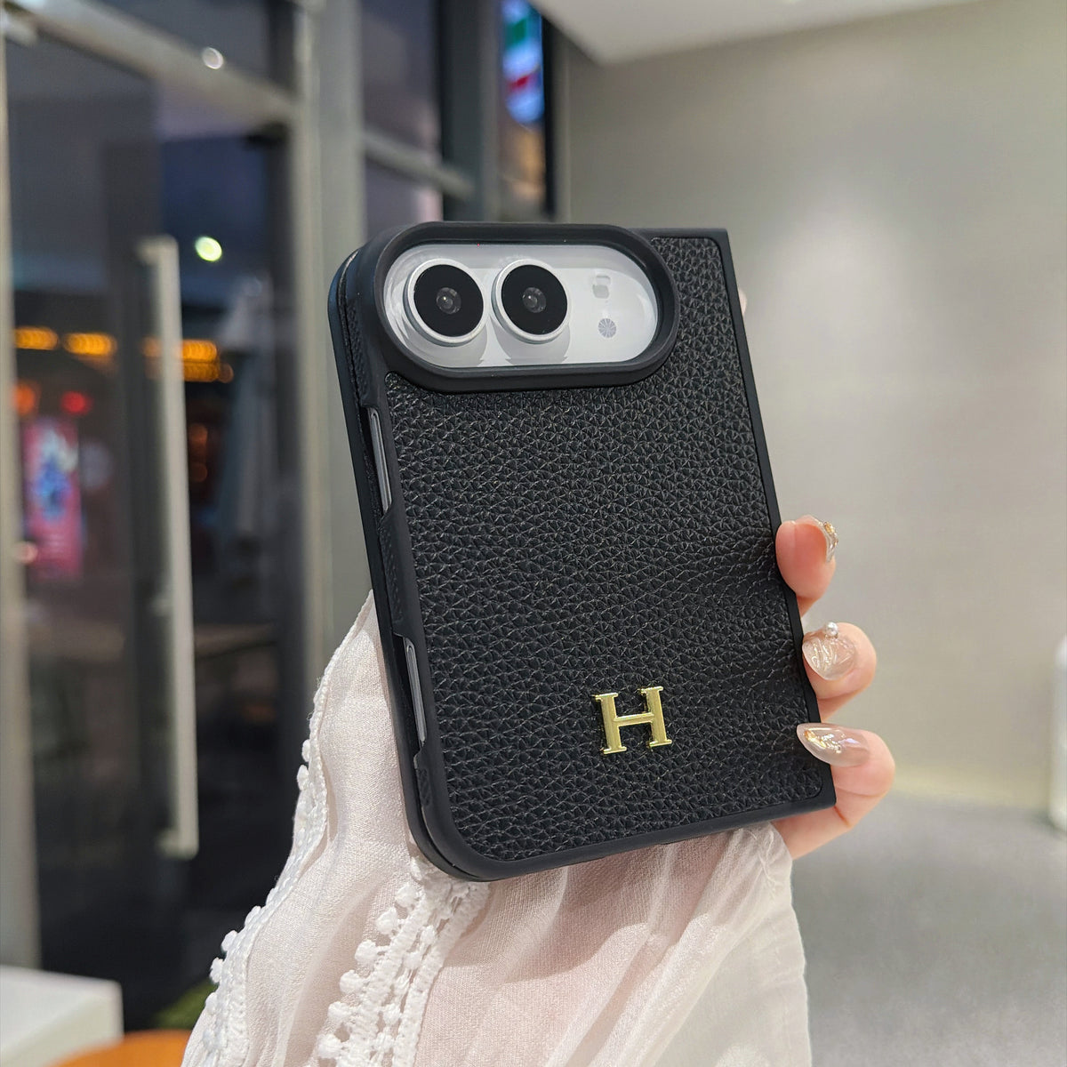 Black pebbled leather-style iPhone Duo case with gold H logo