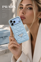Woman holding a Glacier blue Prada-style quilted case for iPhone 18 Pro Max