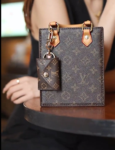 Louis Vuitton monogram mini wallet keychain styled as a bag charm on matching mini tote