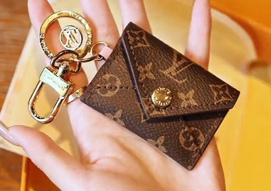 Handheld Louis Vuitton monogram mini wallet keychain with gold-tone clasp and ring hardware