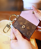 Louis Vuitton monogram mini wallet keychain opened to show pink interior and snap closure